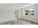 Bright bedroom featuring wood-look flooring, white trim, walls, and ceiling, and a large window at 1518 Lakeside Dr, Deland, FL 32720