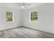 Bright bedroom with two windows, neutral walls, and wood-look flooring at 1518 Lakeside Dr, Deland, FL 32720