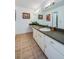 Well-lit bathroom featuring a long vanity with a sink and neutral-toned tile flooring at 152 Sweetgum Ln, Port Orange, FL 32129
