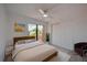 Cozy bedroom features a ceiling fan, closet, and sliding glass doors leading to a balcony at 152 Sweetgum Ln, Port Orange, FL 32129