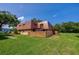 A charming home featuring a unique roofline, fenced yard, and lush green lawn at 152 Sweetgum Ln, Port Orange, FL 32129