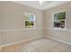An empty bedroom featuring tiled floor, two windows and white walls at 1610 Brady Dr, Deltona, FL 32725