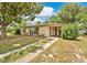 Charming single-story home with a walkway leading up to a covered porch, shaded by a large tree at 1610 Brady Dr, Deltona, FL 32725