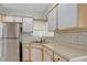 Bright kitchen featuring stainless steel refrigerator, subway tile backsplash and modern white cabinets at 1610 Brady Dr, Deltona, FL 32725