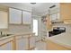 Bright kitchen featuring white cabinets, stainless steel appliances, tile floors, and natural light at 1610 Brady Dr, Deltona, FL 32725