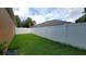 Fenced backyard with green grass and partial view of the neighboring home at 1632 Blue Grass Blvd, Deland, FL 32724
