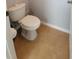 A bathroom with a white toilet, light-grey wall, and tile floor at 1632 Blue Grass Blvd, Deland, FL 32724