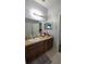 Bathroom with a sink, brown cabinets, and a large mirror above the sink at 1632 Blue Grass Blvd, Deland, FL 32724