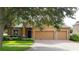 Inviting single-story home with a well-manicured lawn, mature trees, and a brick driveway leading to a two-car garage at 1632 Blue Grass Blvd, Deland, FL 32724