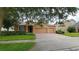 Charming home with a two-car garage, lush landscaping, and a paved driveway at 1632 Blue Grass Blvd, Deland, FL 32724