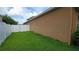 Side yard featuring healthy green grass and a white privacy fence at 1632 Blue Grass Blvd, Deland, FL 32724