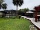 Landscaped backyard with a pool, deck, pergola, and mature trees at 180 Pine Grove Ct, Daytona Beach, FL 32119