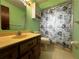 Bathroom with a wooden vanity, mirror, and shower, featuring a vibrant color scheme at 180 Pine Grove Ct, Daytona Beach, FL 32119