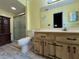 Well-lit bathroom with a wooden vanity, toilet, and a shower with glass doors at 180 Pine Grove Ct, Daytona Beach, FL 32119