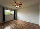 Inviting bedroom featuring wood floors, a modern ceiling fan, and a large window at 180 Pine Grove Ct, Daytona Beach, FL 32119