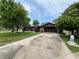 Charming single-story brick home featuring an attached garage and long driveway, nestled on a well-maintained, grassy lot at 180 Pine Grove Ct, Daytona Beach, FL 32119