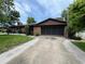 Charming single-story brick home with a well-maintained lawn and a screen-enclosed two-car garage at 180 Pine Grove Ct, Daytona Beach, FL 32119