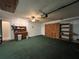 View of the interior of a garage with ample storage, counter space, and green carpet at 180 Pine Grove Ct, Daytona Beach, FL 32119