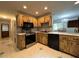 Well-lit kitchen with wooden cabinets, stainless steel appliances, and stylish tiled floors at 180 Pine Grove Ct, Daytona Beach, FL 32119