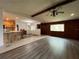 Bright living room boasts hardwood floors, wood-paneled wall, and an open floorplan to the kitchen at 180 Pine Grove Ct, Daytona Beach, FL 32119