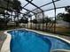 Screened-in pool surrounded by lush landscaping and privacy fencing at 180 Pine Grove Ct, Daytona Beach, FL 32119