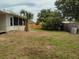 Fenced backyard with mature trees and a palm tree near the house at 1821 Talmadge St, Deland, FL 32724
