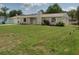 Charming single-story home featuring an attached garage, solar panels, and a well-maintained lawn at 1821 Talmadge St, Deland, FL 32724