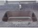 Close-up of a kitchen sink set in granite countertops with a brushed nickel faucet at 1821 Talmadge St, Deland, FL 32724