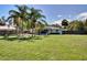 A large backyard with trees and grass surrounding a white home with a fenced in yard at 1828 West Pkwy, Deland, FL 32724