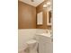 Cozy bathroom featuring a toilet, sink, mirror, and wainscotting at 1828 West Pkwy, Deland, FL 32724