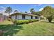 Well-maintained single-story home with lush, trimmed landscaping around the foundation at 1828 West Pkwy, Deland, FL 32724