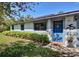 Charming home featuring a bright blue front door and manicured shrubbery at 1828 West Pkwy, Deland, FL 32724