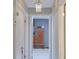 Hallway featuring decorative chandelier and an antique wardrobe at the end at 1828 West Pkwy, Deland, FL 32724