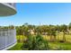 Balcony overlooking lush palm trees and tropical landscaping with a distant skyline at 2 Oceans West Blvd # 305, Daytona Beach, FL 32118