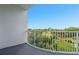 Balcony with white railings overlooking a green field and lush tropical trees at 2 Oceans West Blvd # 305, Daytona Beach, FL 32118