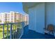 Condo balcony view overlooking palm trees and buildings with a blue floor at 2 Oceans West Blvd # 305, Daytona Beach, FL 32118
