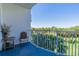 Relaxing balcony view overlooking green space, with a wicker chair and small table at 2 Oceans West Blvd # 305, Daytona Beach, FL 32118