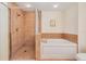 Bathroom features a tiled glass-enclosed shower and soaking tub with tile surround at 2 Oceans West Blvd # 305, Daytona Beach, FL 32118