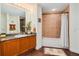 Bathroom features granite counters, wood cabinets and a tub with tiled surround at 2 Oceans West Blvd # 305, Daytona Beach, FL 32118
