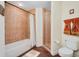 Bathroom with tiled floors, tub and separate glass shower, and toilet at 2 Oceans West Blvd # 305, Daytona Beach, FL 32118