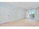 Bright bedroom with neutral carpet, balcony access, and a ceiling fan at 2 Oceans West Blvd # 305, Daytona Beach, FL 32118