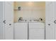 Bright laundry area featuring a white washer and dryer, with storage shelf above at 2 Oceans West Blvd # 305, Daytona Beach, FL 32118