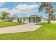 Light green home with a concrete driveway, green grass lawn and a screened-in porch at 203 Fox Pl, Port Orange, FL 32127