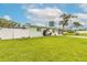 View of the front of the light green house with a white fence and a lush green lawn at 203 Fox Pl, Port Orange, FL 32127