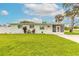 Charming light green one-story home featuring a well-manicured front yard and screened entryway at 203 Fox Pl, Port Orange, FL 32127