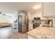 Open-concept kitchen and living room with stainless steel refrigerator and modern decor at 203 Fox Pl, Port Orange, FL 32127