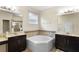 Bathroom with separate vanities, garden tub, and tiled shower at 218 Wellington Woods Ave, Deland, FL 32724