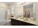 Bathroom featuring double sinks, granite countertop, large mirror, and bathtub at 218 Wellington Woods Ave, Deland, FL 32724