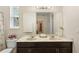Bathroom featuring double sinks, granite countertop, large mirror and natural light at 218 Wellington Woods Ave, Deland, FL 32724