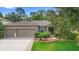 A well-maintained, single-story home with a two-car garage, complemented by a manicured lawn and landscaped front yard at 218 Wellington Woods Ave, Deland, FL 32724